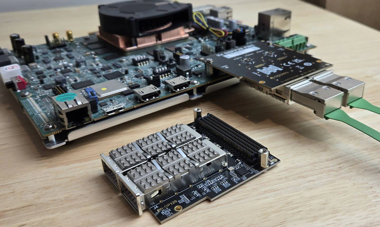 photo of two FMCs - one connected to the VEK280 with QSFP28 loopback modules plugged in, the other sitting beside it component-side up